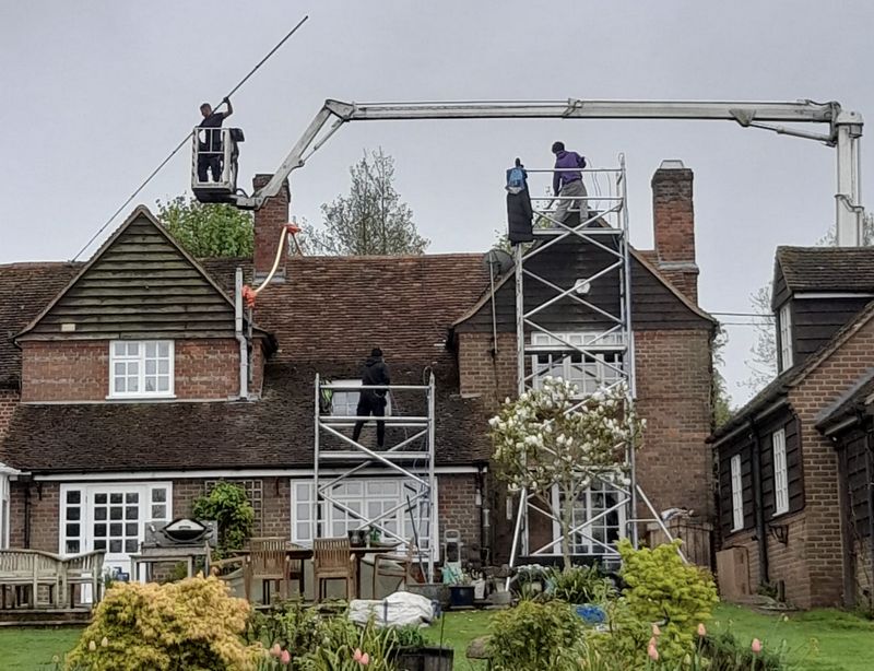 The Moss Cleaners using cherry picker and scaffolding to clean roof safely and professionally in Cobham, Surrey